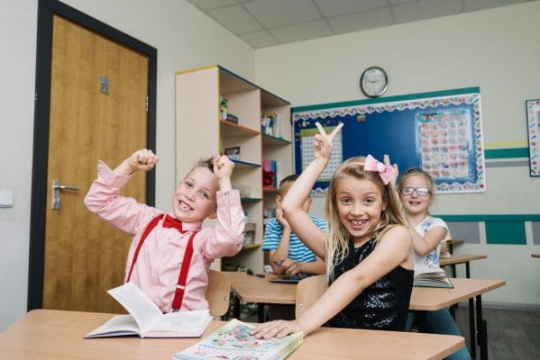 Schoolchildren Sitting Desks Posing